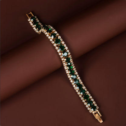 Gold-tone tennis bracelet with green rectangular stones and clear stone borders.