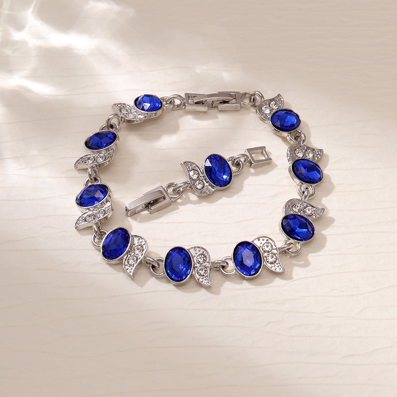 Silver-tone bracelet with blue oval stones, clear leaf accents and a clasp.