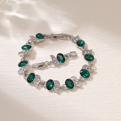 Silver-tone bracelet with green oval stones, clear leaf accents and a clasp.