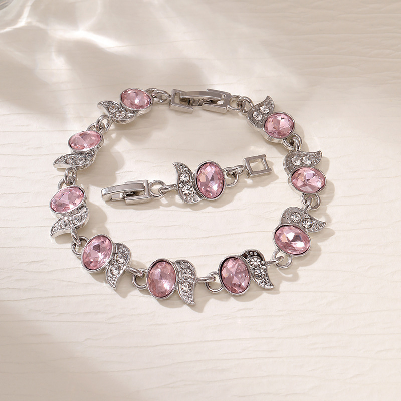 Silver-tone bracelet with pink oval stones, clear leaf accents and a clasp.