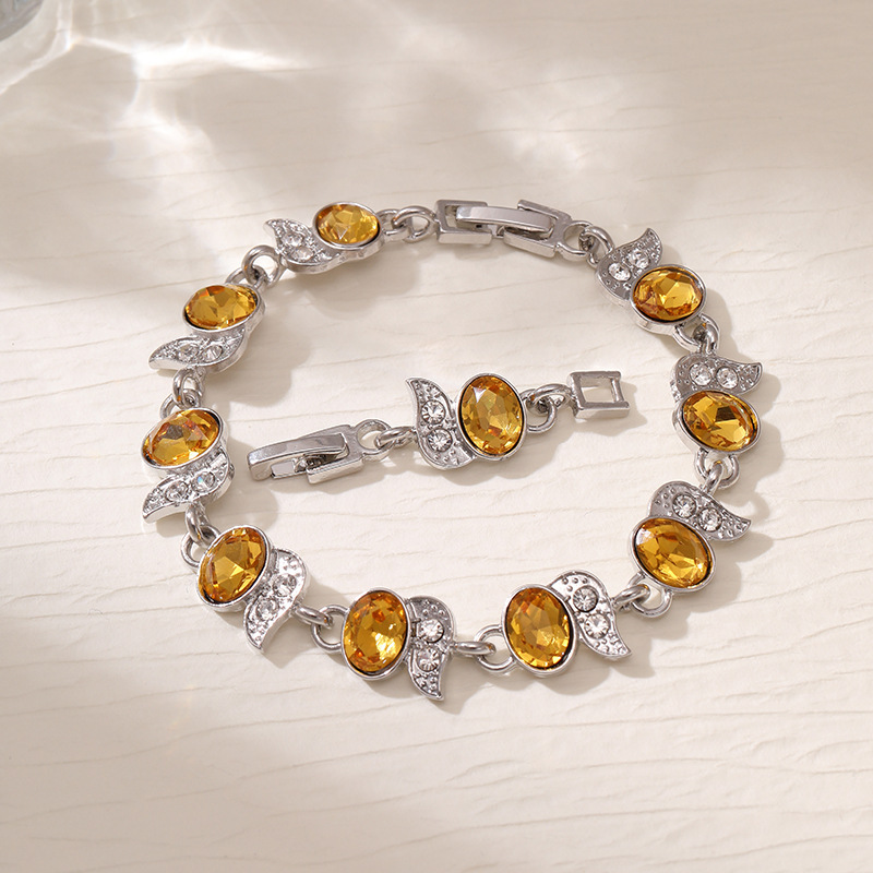 Silver-tone bracelet with yellow oval stones, clear leaf accents and a clasp.