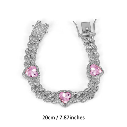 Silver Tone Cuban link bracelet with three pink heart-shaped accents and a clasp; 20 cm.