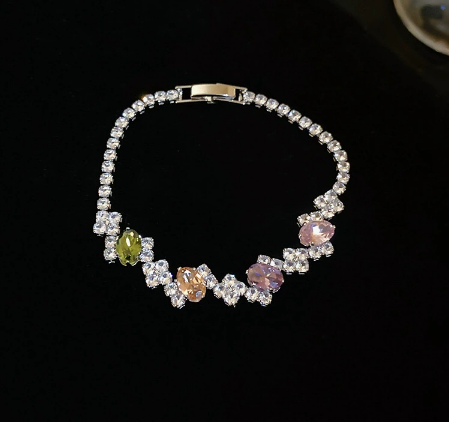 21 - Silver Tone / Multicolor tennis bracelet with center stones, small clear geometric clusters and a clasp.