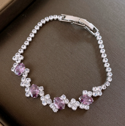27 - Silver Tone / Purple tennis bracelet with center stones, small clear geometric clusters and a clasp.