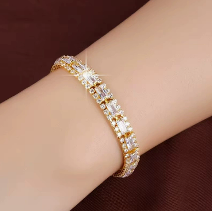 Gold-tone three-row bracelet with clear rectangular center stones bordered by small clear accents.
