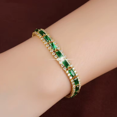 Gold-tone three-row bracelet with green rectangular center stones bordered by small clear accents.