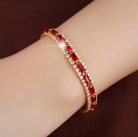 Gold-tone three-row bracelet with red rectangular center stones bordered by small clear accents.