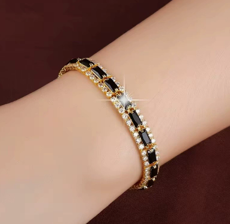Gold-tone three-row bracelet with black rectangular center stones bordered by small clear accents.