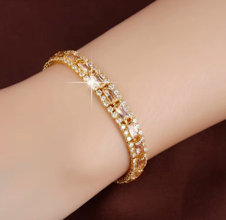 Gold-tone three-row bracelet with champagne rectangular center stones bordered by small clear accents.