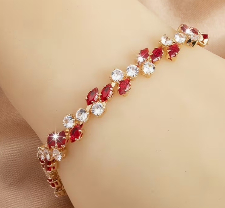 Gold-tone bracelet with red marquise-shaped stones and round clear accents in a leaf-like pattern.