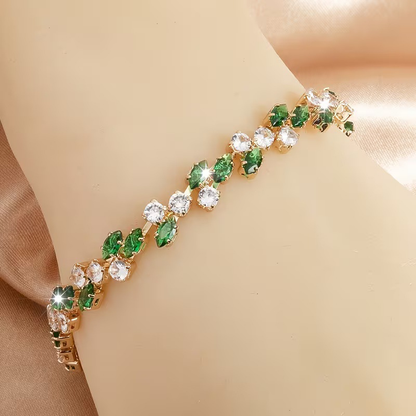 Gold-tone bracelet with green marquise-shaped stones and round clear accents in a leaf-like pattern.