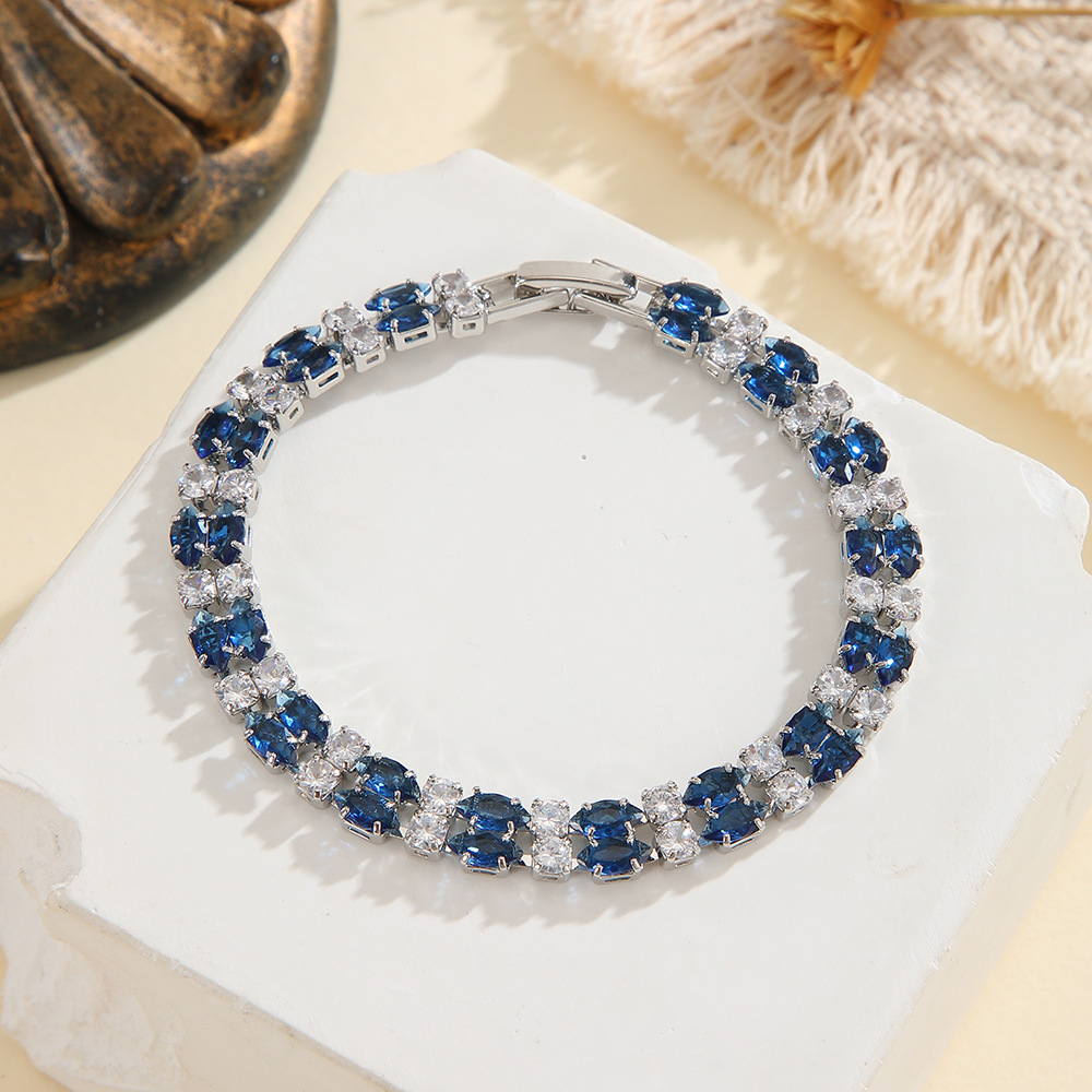 Silver-tone double-row bracelet in clear / blue with paired marquise-shaped stones and small round accents.