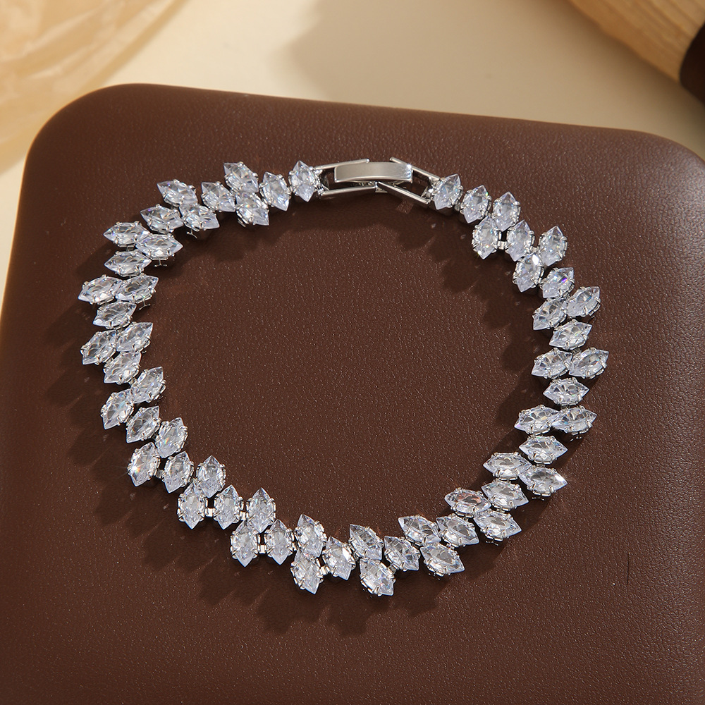 Silver-tone leaf-wreath bracelet in clear with angled marquise-shaped stones and a clasp.