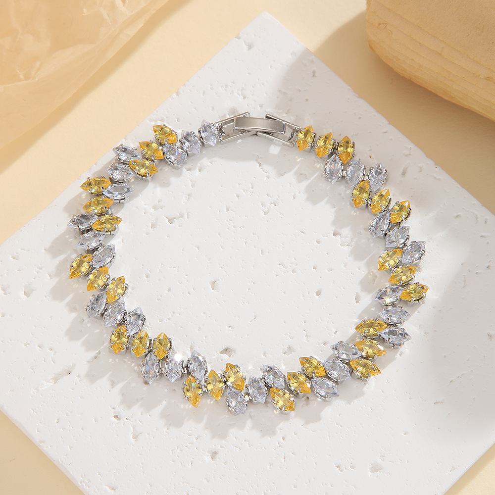 Silver-tone leaf-wreath bracelet in clear / golden yellow with angled marquise-shaped stones and a clasp.