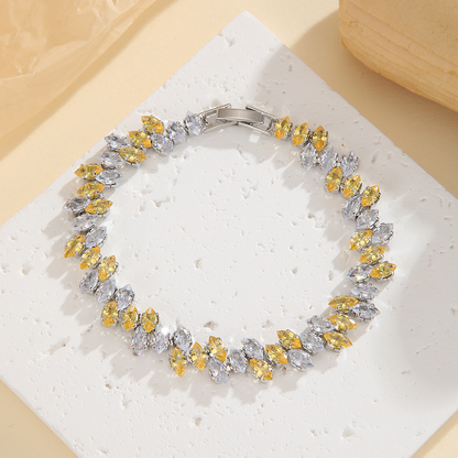 Silver-tone leaf-wreath bracelet in clear / golden yellow with angled marquise-shaped stones and a clasp.