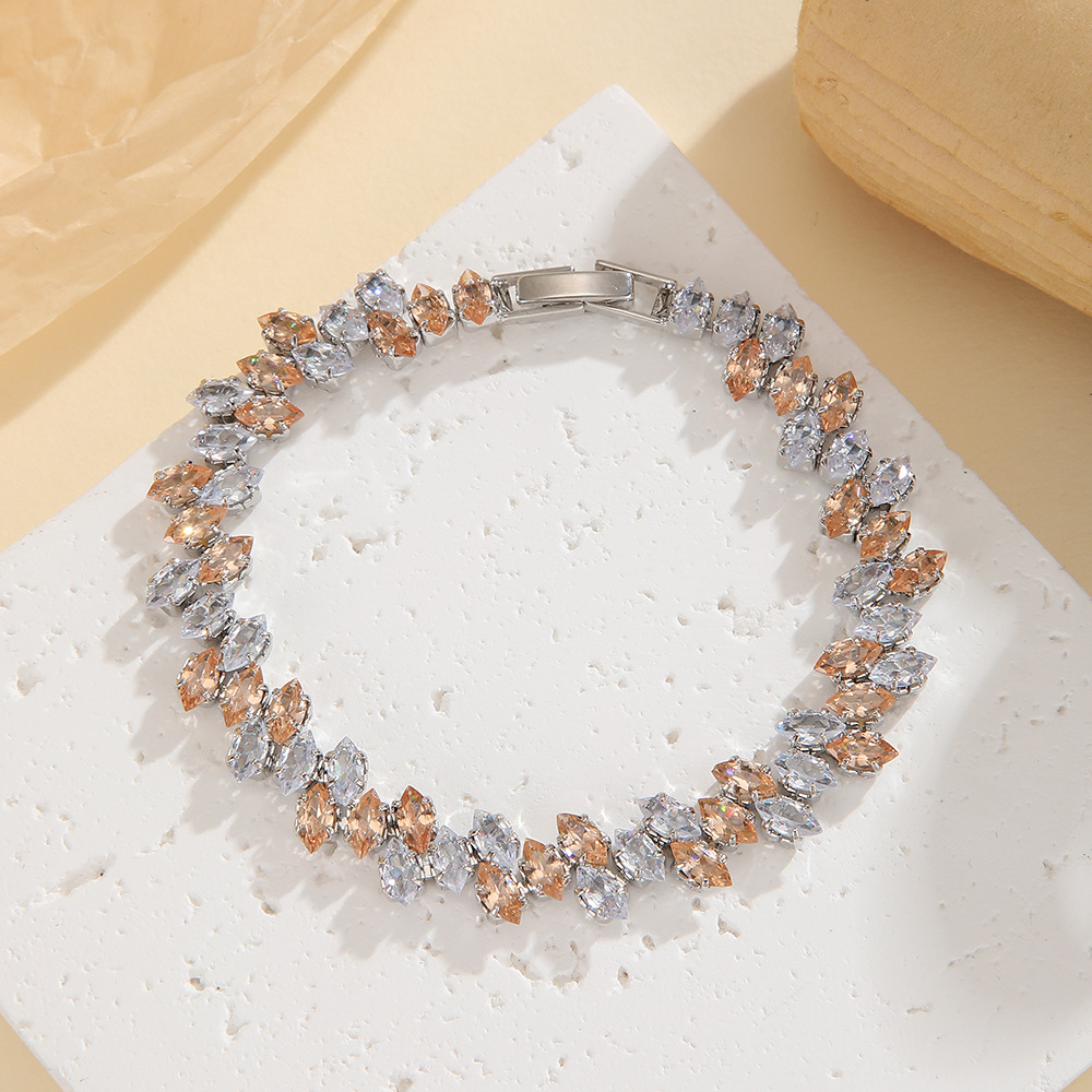 Silver-tone leaf-wreath bracelet in clear / champagne with angled marquise-shaped stones and a clasp.