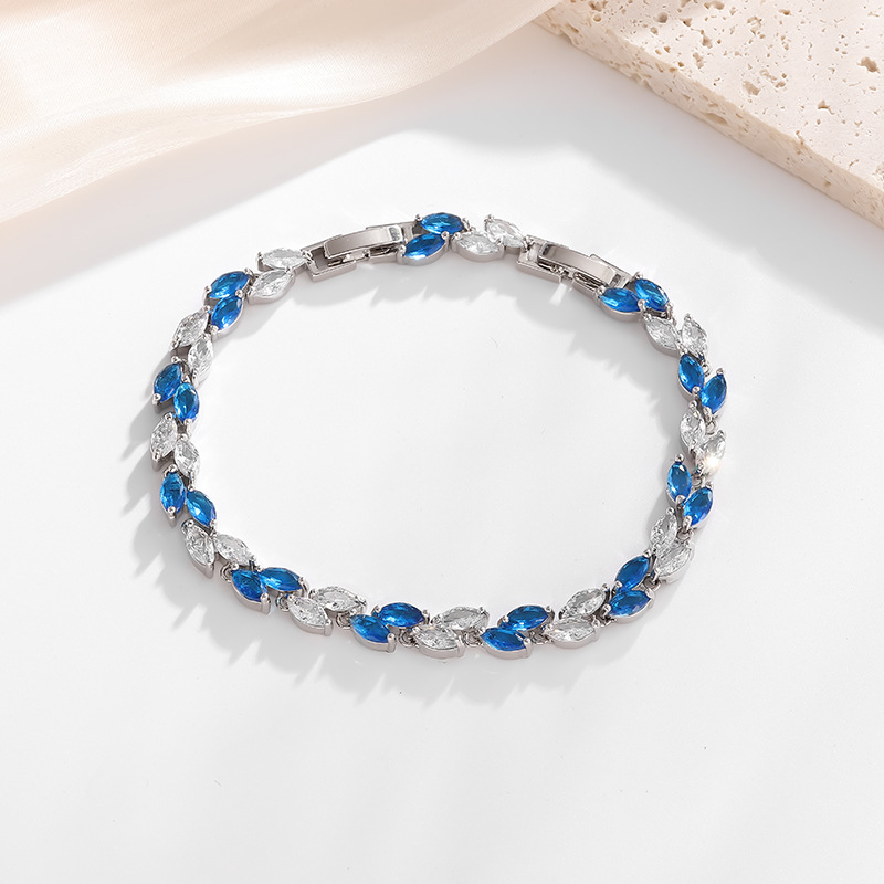 Silver-tone petite leaf bracelet with blue stone accents and a clasp.