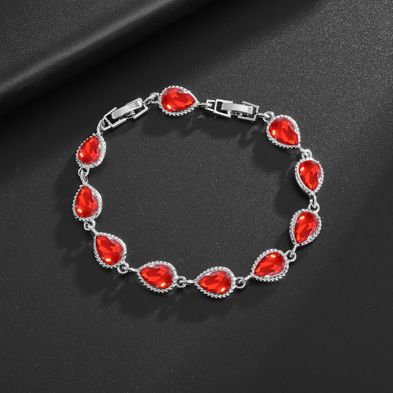 Silver-tone bracelet with red teardrop center stones, clear halo accents and a clasp.