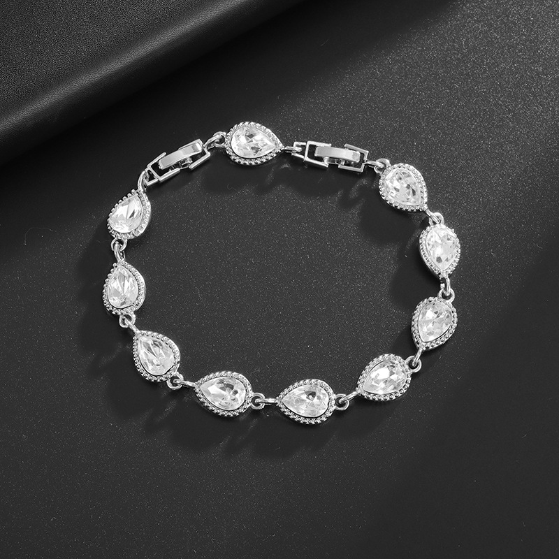 Silver-tone bracelet with clear teardrop center stones, clear halo accents and a clasp.