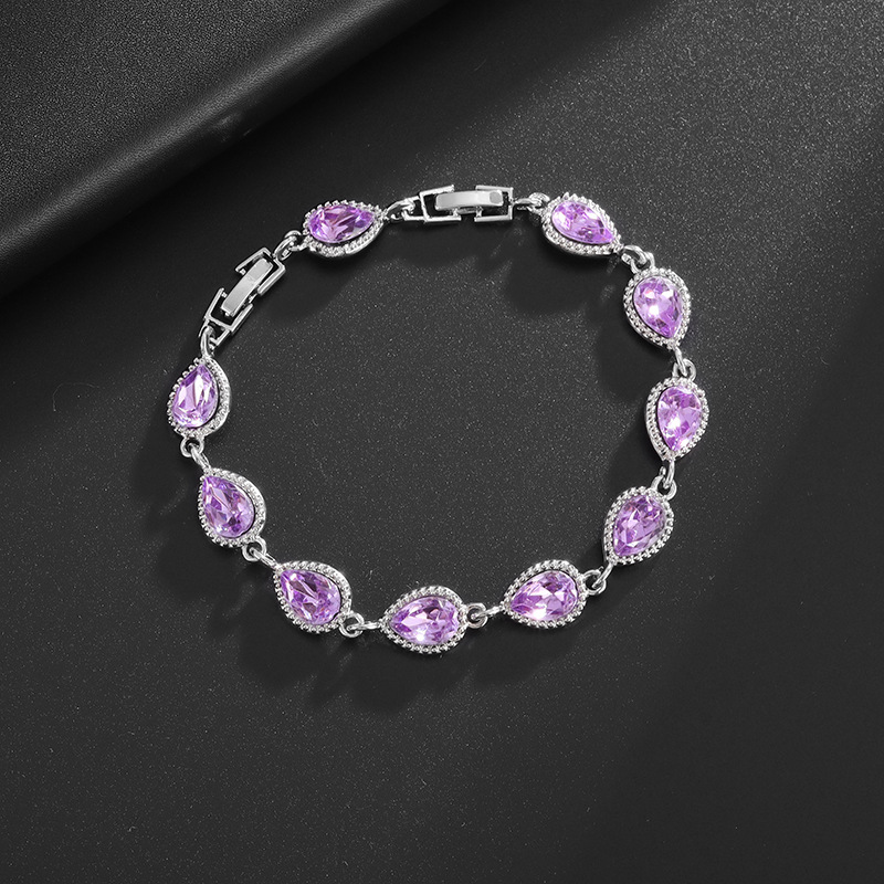 Silver-tone bracelet with purple teardrop center stones, clear halo accents and a clasp.