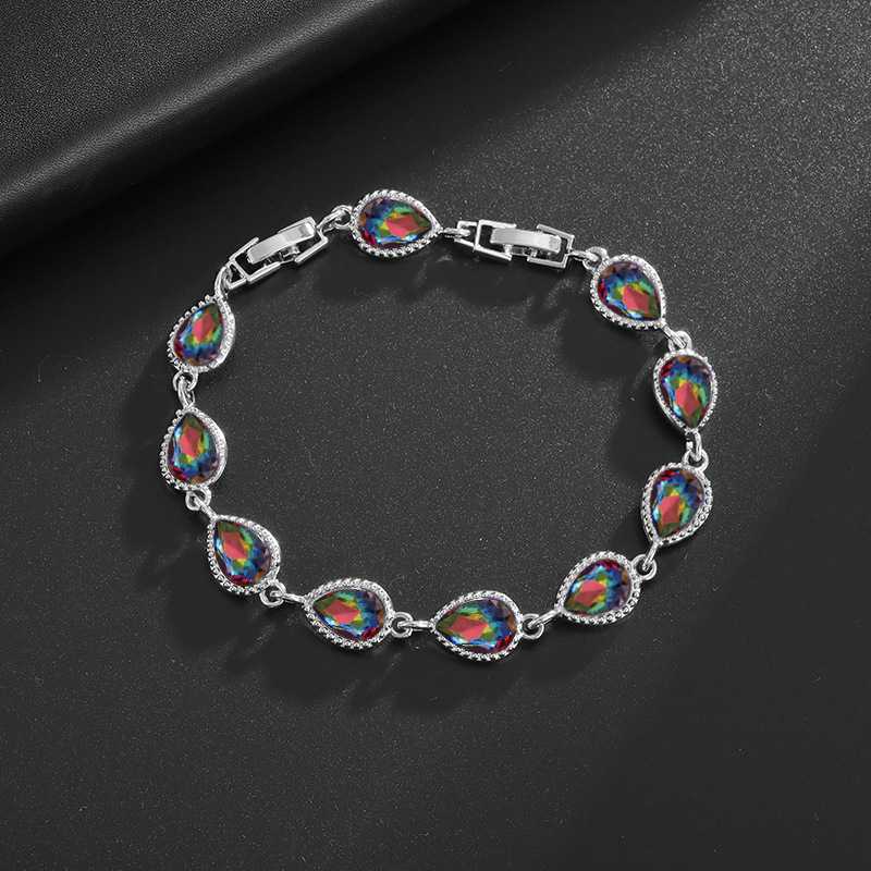 Silver-tone bracelet with iridescent rainbow teardrop center stones, clear halo accents and a clasp.