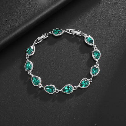 Silver-tone bracelet with green teardrop center stones, clear halo accents and a clasp.