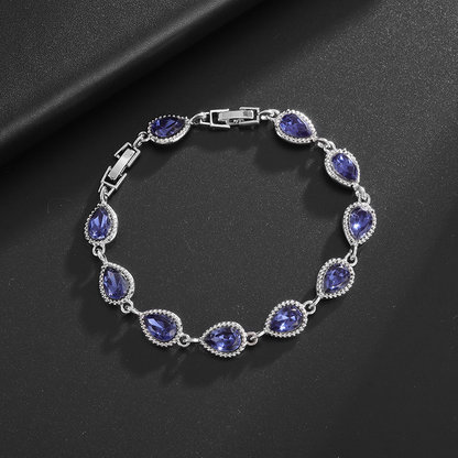 Silver-tone bracelet with blue teardrop center stones, clear halo accents and a clasp.