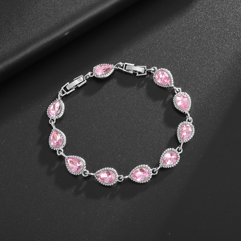 Silver-tone bracelet with pink teardrop center stones, clear halo accents and a clasp.