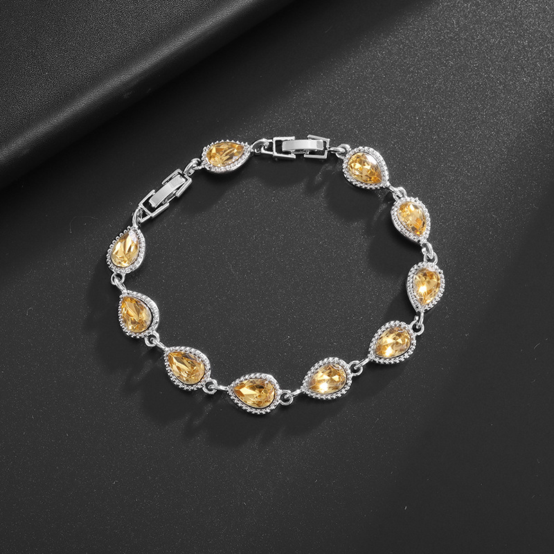 Silver-tone bracelet with champagne teardrop center stones, clear halo accents and a clasp.