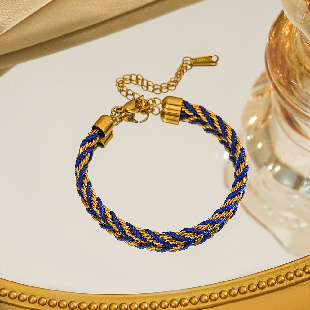 Braided bracelet in blue / gold tone with gold-tone end caps, a lobster clasp and extension chain.