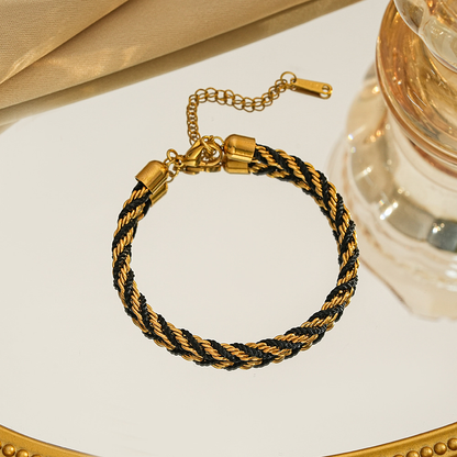 Braided bracelet in black / gold tone with gold-tone end caps, a lobster clasp and extension chain.