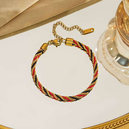 Braided bracelet in red / black / gold tone with gold-tone end caps, a lobster clasp and extension chain.