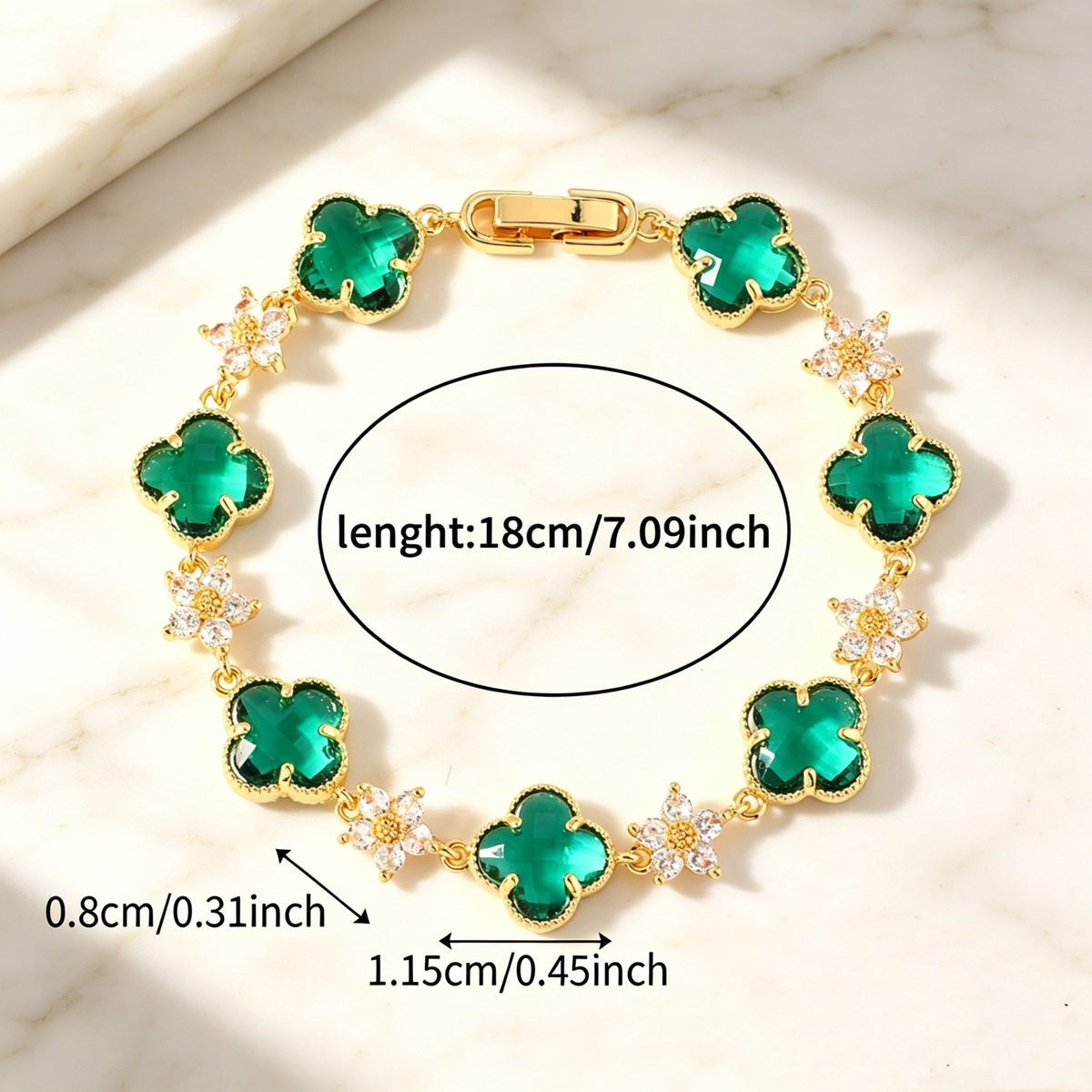 Gold Tone bracelet with green four-leaf clovers and small clear flower links; length 18 cm.