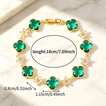 Gold Tone bracelet with green four-leaf clovers and small clear flower links; length 18 cm.