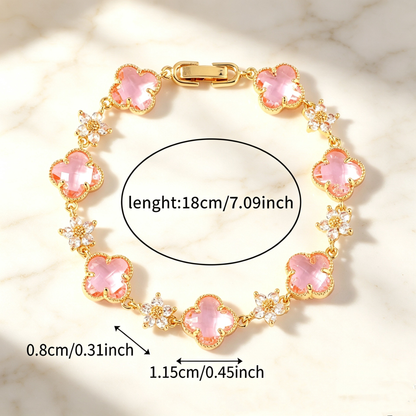 Gold Tone bracelet with pink four-leaf clovers and small clear flower links; length 18 cm.