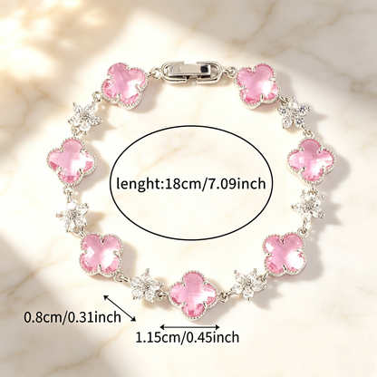 Silver Tone bracelet with pink four-leaf clovers and small clear flower links; length 18 cm.