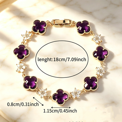 Gold Tone bracelet with purple four-leaf clovers and small clear flower links; length 18 cm.