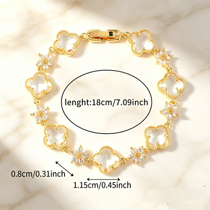 Gold Tone bracelet with clear four-leaf clovers and small clear flower links; length 18 cm.