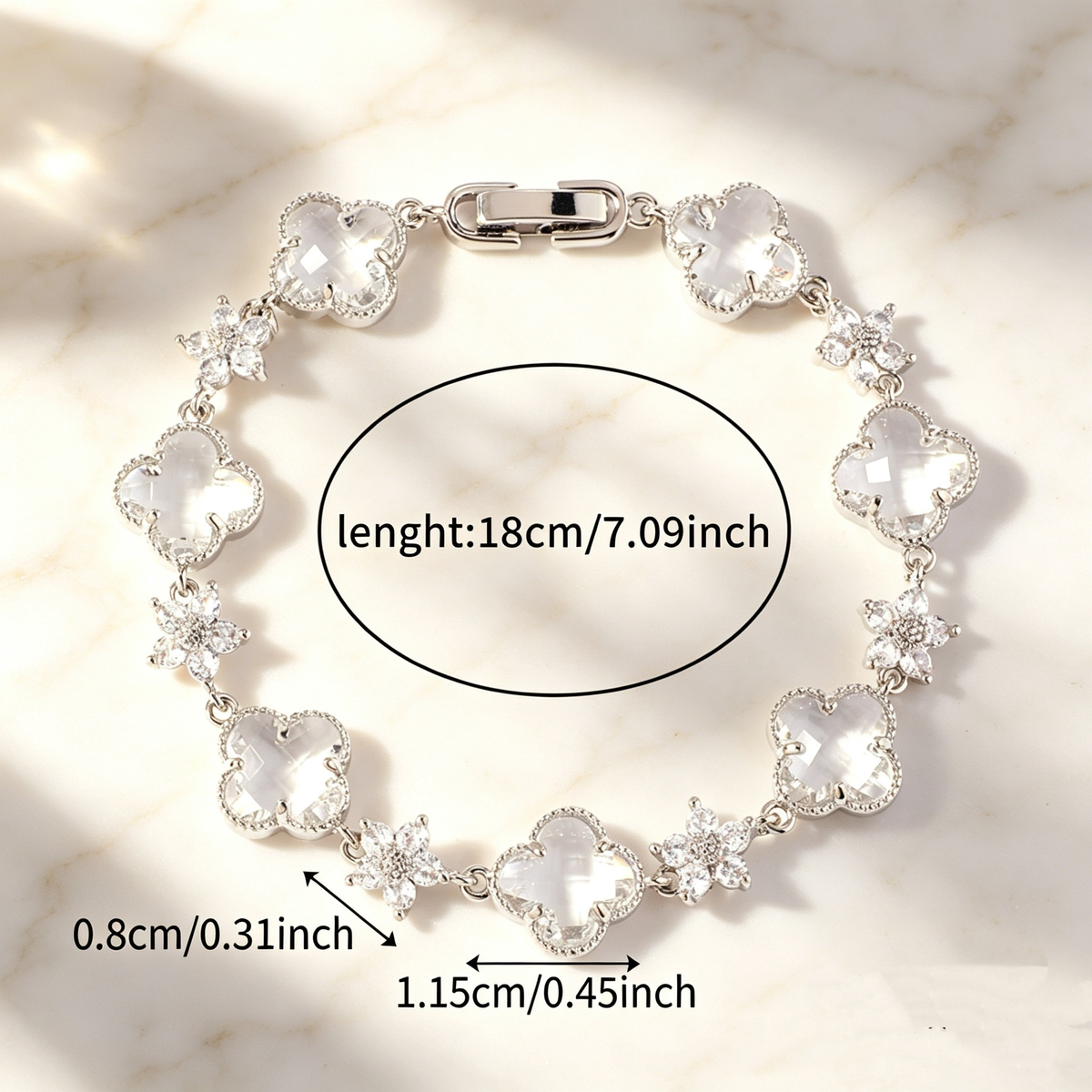 Silver Tone bracelet with clear four-leaf clovers and small clear flower links; length 18 cm.