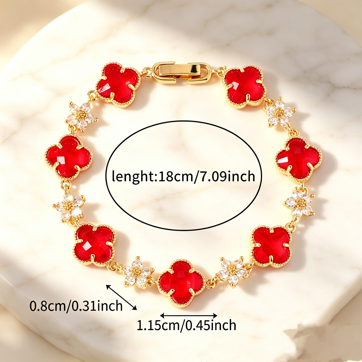 Gold Tone bracelet with red four-leaf clovers and small clear flower links; length 18 cm.