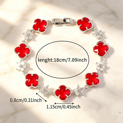 Silver Tone bracelet with red four-leaf clovers and small clear flower links; length 18 cm.