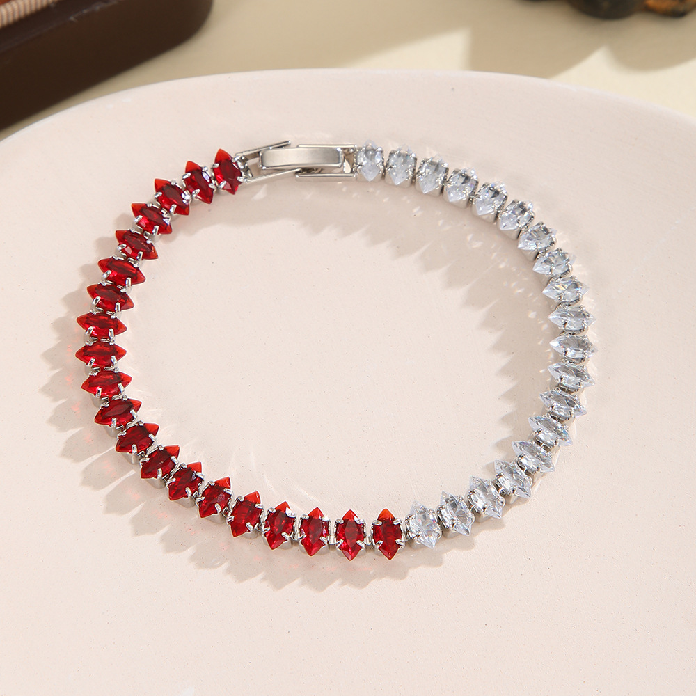 Silver-tone bracelet with separate clear / red sections of marquise-shaped stones and a clasp.