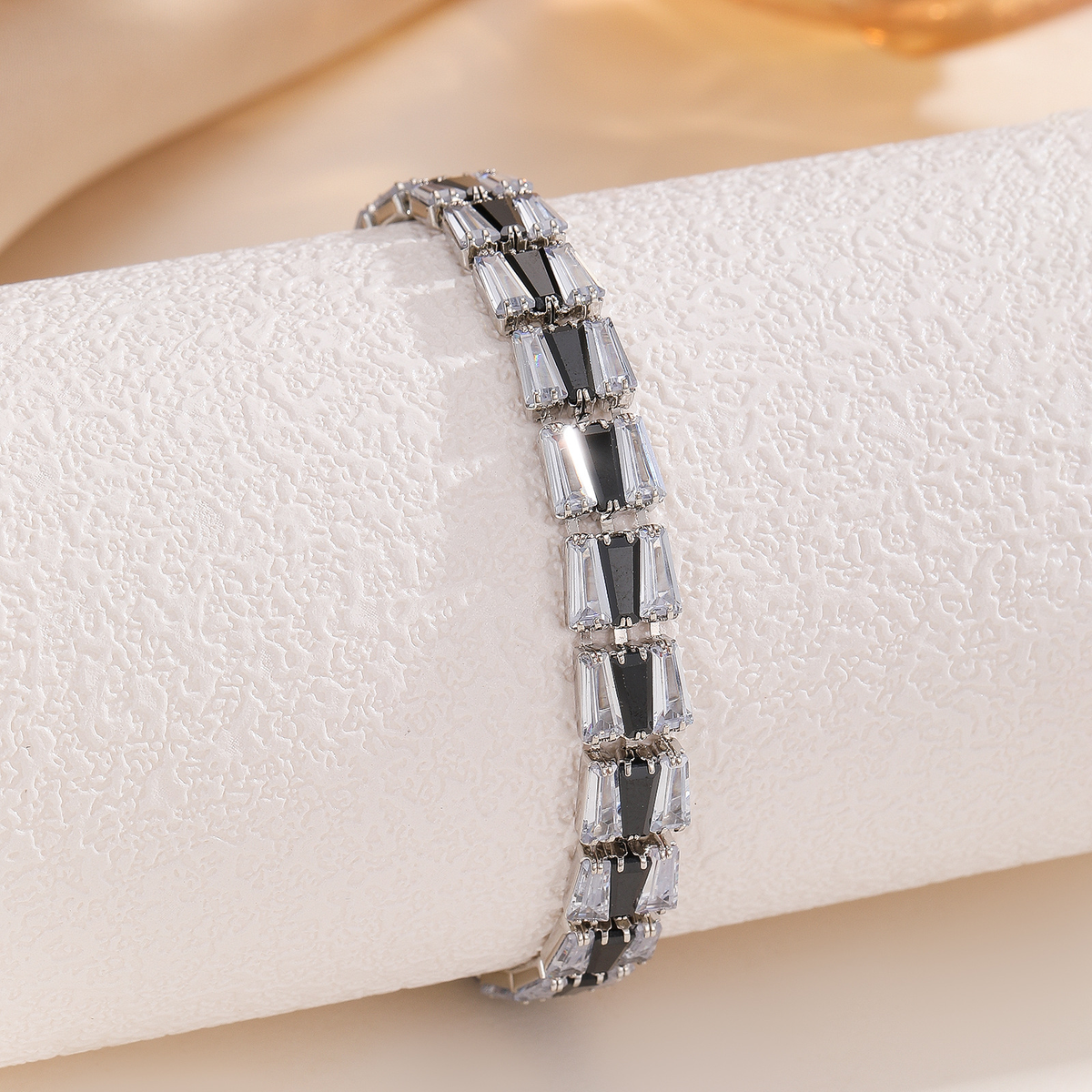 Silver-tone bracelet with three-stone geometric panels in the black center / clear sides arrangement.