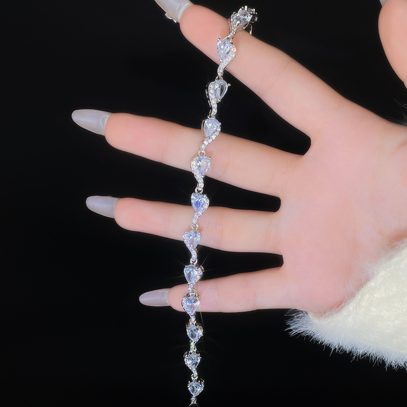 Silver-tone bracelet with repeating clear teardrop-shaped stones and curved connecting accents.