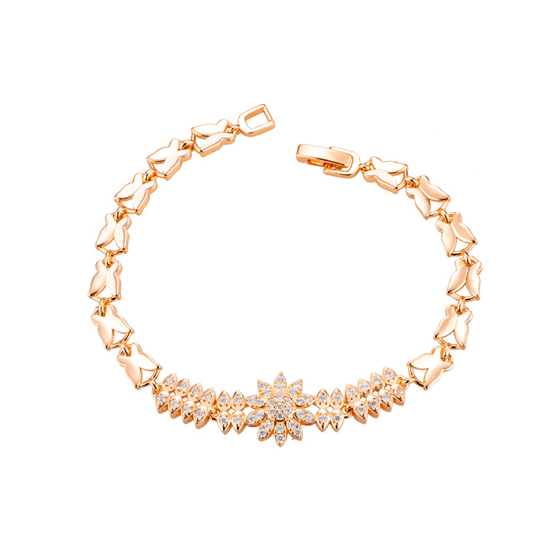 Gold-tone bracelet with butterfly-shaped links and a clear stone-set flower center.