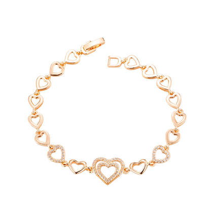 Gold-tone open-heart link bracelet with a larger stone-set heart center and two smaller heart accents.