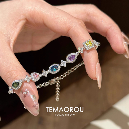 Silver-tone adjustable bracelet with multicolor halo-set accents in assorted shapes.