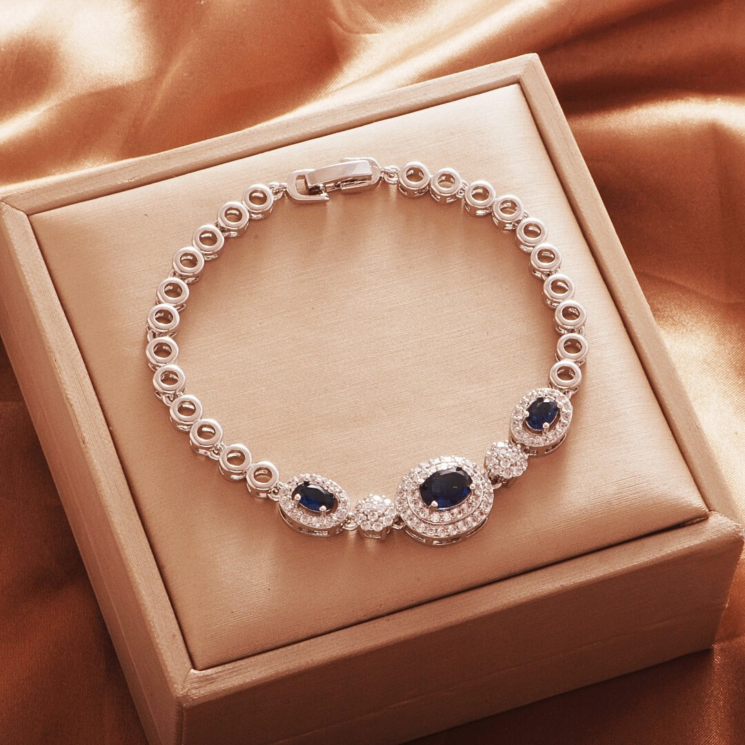 Silver Tone bracelet, style TSL003, with dark blue oval halo centers and round links and a clasp.