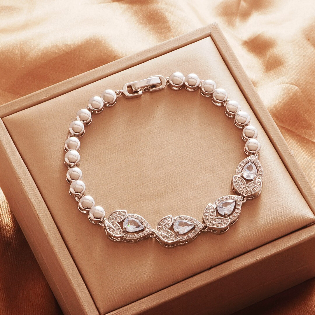 Silver Tone bracelet, style TSL006, with teardrop halo centers and rounded links and a clasp.