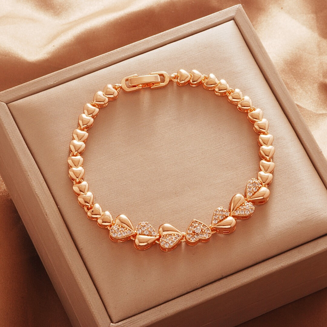 Gold Tone bracelet, style TSL012, with heart-shaped links and round center accents and a clasp.